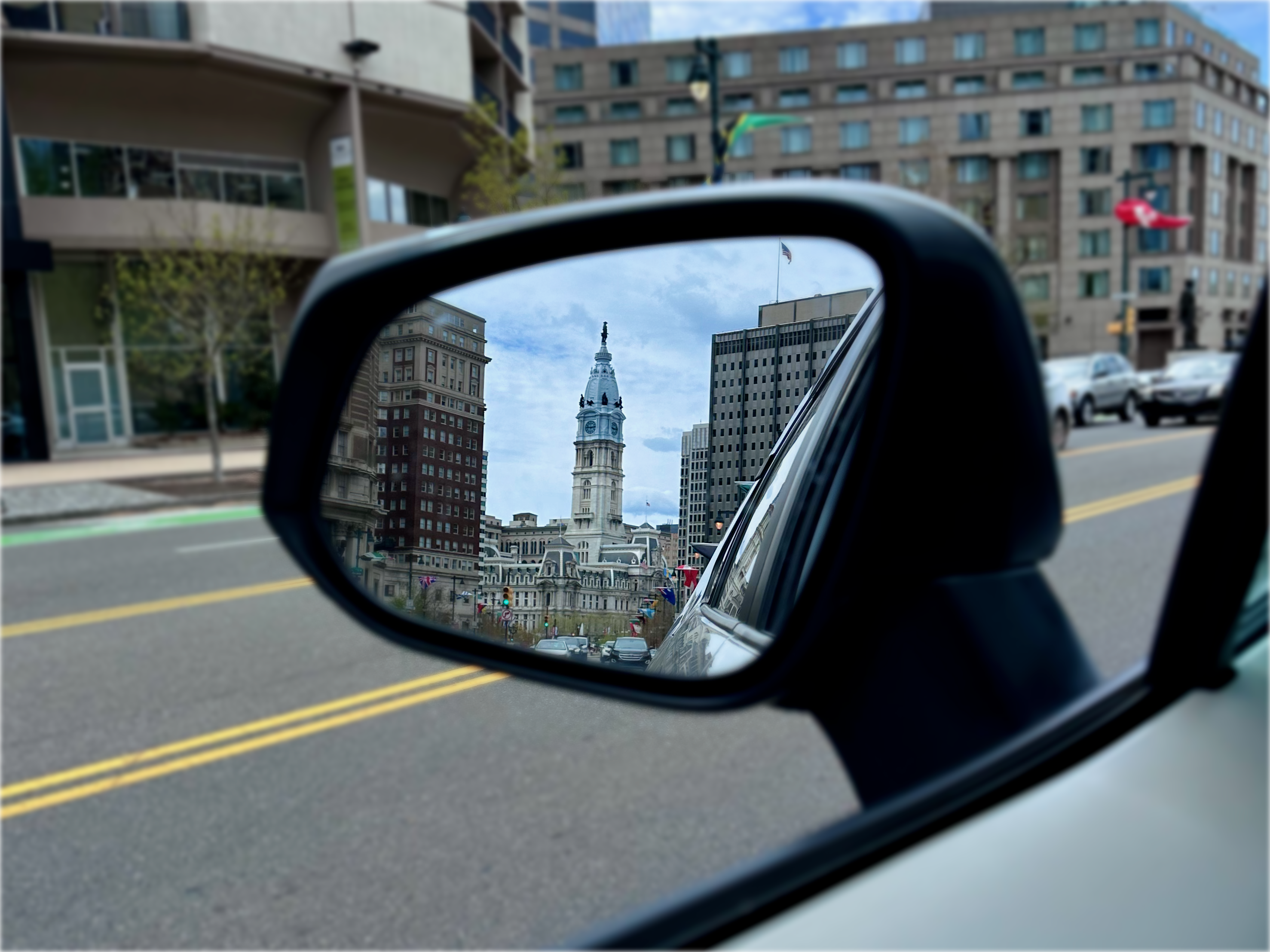 Rearview mirror reflection of Philly Town Hall